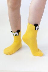Baby Feet In Bright Yellow Socks On White Background. Cotton socks