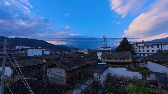 A time-lapse of traditional residential rooftops in Lijiang unfolds with shifting light&mdash;showcasing tiled roofs, carved wood structures, and a serene mountain backdrop that blends heritage and everyday