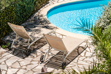 Transats au bord d’une piscine courbe