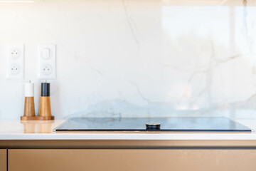 Détail de cuisine moderne avec plaque à induction et moulins à épices