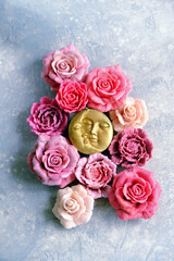 moon amulet and artificial pink-red rose flowers close up on abstract light grey background. Magic, esoteric spiritual ritual with moon symbol. witchcraft. Love, romantic vibes. top view
