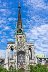Gothic architecture of Rouen Cathedral showcases intricate details under a bright blue sky