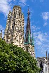 Gothic architecture of Rouen Cathedral showcases intricate details under a bright blue sky
