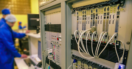Network equipment setup in a modern IT facility with technicians working on servers