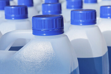 Plastic jars with blue liquid for windshield washer fluid close up