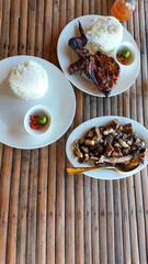 Grilled chicken inasal and pork liempo paired with rice served on a bamboo table, authentic traditional local Filipino meal in the Philippines