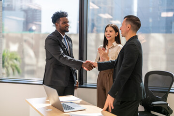 Multiracial team collaborating in modern office, diverse colleagues shaking hands during a business meeting, teamwork success, partnership agreement, professional collaboration multicultural workplace