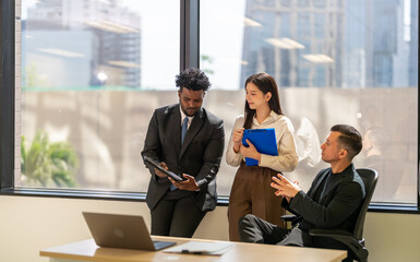 Diverse business team brainstorming together, strategic planning with tablet in office, inclusive...