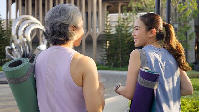 Young adult aged mature middle age old female at public park walk hold water bottle yoga mat. Self Love health care older woman asia elder people happy protect aging life enjoy sport club class active - Powered by Adobe