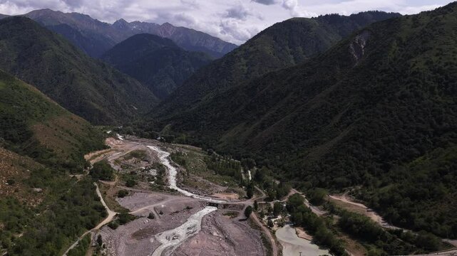 A protective dam against mudflows. Talgar gorge, Tian Shan Mountains. Different vegetation and a mountain river. The view from the drone.