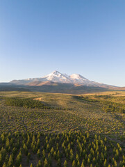 Fototapeta premium Beautiful Mount Shasta volcano with snow and glacier visible, in early summer morning sunlight, aerial view, portrait mode 