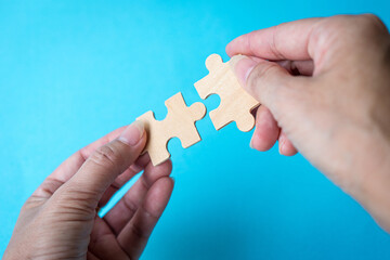 Hand holding jigsaw puzzle pieces. Matching, collaboration or teamwork concept.