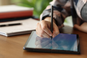 Student hand using tablet to handwrite notes