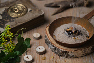 Incense ritual at wheel of the year festival Samhain with frankincense, myrrh and dried herbs in...