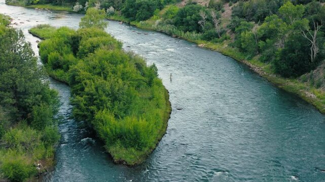 A slow pan across the Animas from above, highlighting color shifts in the water, the flow, and subtle movement in the landscape. Two fisherman cast their fly fishing rods while wading.