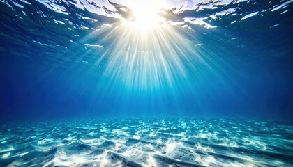 Ocean Sunlight: Sunbeams pierce the deep blue ocean, illuminating the sandy seabed in a breathtaking underwater scene.