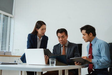 Professional business team meeting with consultant and project planning charts.