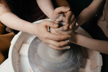 Close-up of hands shaping clay on pottery wheel in studio Creative ceramic art and mindful craft