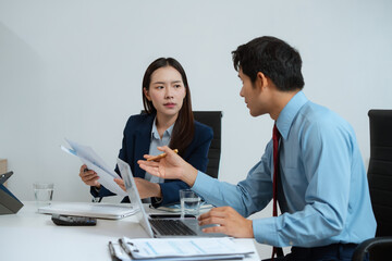 Business team analyzing documents, graphs, and data with a laptop, tablet, and smartphone....