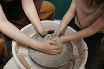Close-up of hands shaping clay on pottery wheel in studio Creative ceramic art and mindful craft