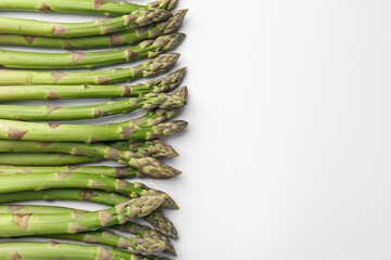 Fresh ripe raw asparagus on white background, flat lay. Space for text