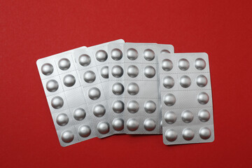 blisters with pills, pills, on a red background