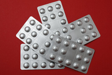 blisters with pills, pills, on a red background