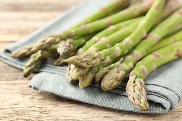 Fresh raw asparagus spears on wooden table, closeup