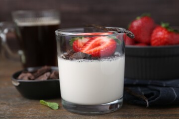 Tasty panna cotta with chocolate, strawberries, mint and vanilla pods on wooden table, closeup