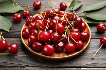 Fresh ripe cherries on black wooden table, closeup