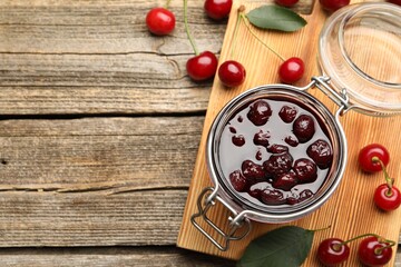 Tasty cherry jam and fresh fruits on wooden table, flat lay. Space for text