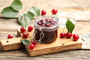Tasty cherry jam and fresh fruits on wooden table, closeup