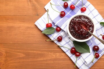 Tasty cherry jam and fresh fruits on wooden table, flat lay. Space for text