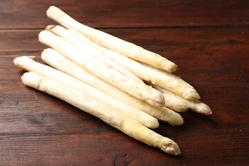 Many raw asparagus spears on wooden table, closeup