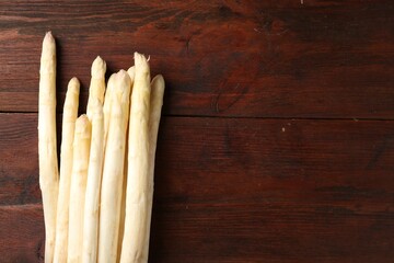 Many raw asparagus spears on wooden table, top view. Space for text