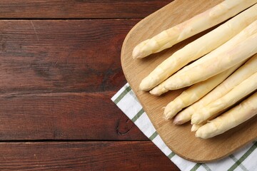 Raw asparagus spears on wooden table, top view. Space for text