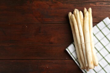Raw asparagus spears on wooden table, top view. Space for text