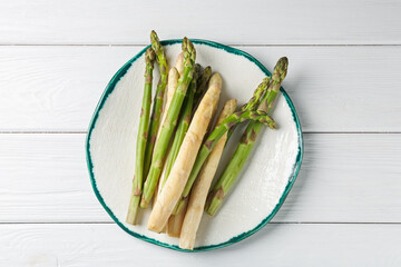 Different raw asparagus spears on white wooden table, top view