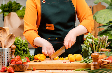 Chef prepares fresh vegetables for a healthy vegan meal in a cozy kitchen, showcasing culinary...