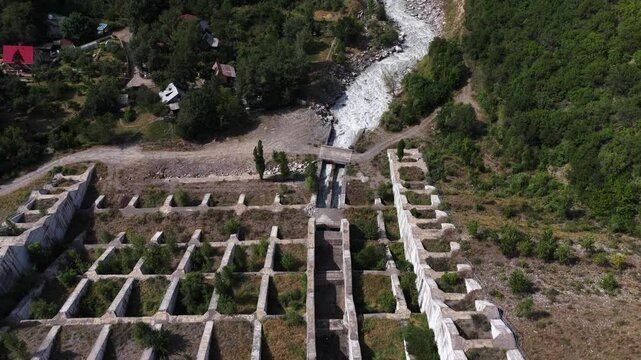 A protective dam against mudflows. Talgar gorge, Tian Shan Mountains. Different vegetation and a mountain river. The view from the drone.