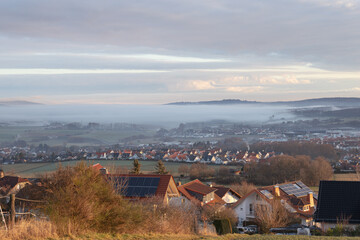 Herbstliche Sonnenaufgangsstimmung im Nebel mit Blick auf die Kleinstadt Neu-Anspach, aufgenommen...