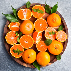Tangerines or mandarines on a tray. Close up of citrus fruits. On a concrete background.