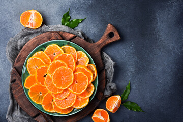 Cut mandarin slices on a plate are ready to eat. Close up macro, top view.