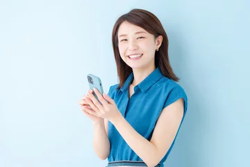 Fotobehang スマホ　女性　ブルーバック © naka