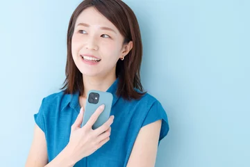 Fotobehang スマホ　女性　ブルーバック © naka