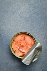 A metal can with tuna in oil. Food stocks. On a gray concrete background.