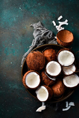 Cracked coconuts in shell with coconut milk on old vintage background. Top view. Free space for text or design.