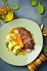 Veal steak with enoki mushrooms and potatoes. In a plate. Restaurant dish. Close up.