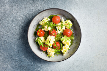 Spinach cream puree with cherry tomatoes and arugula. Cold snacks. In a plate.