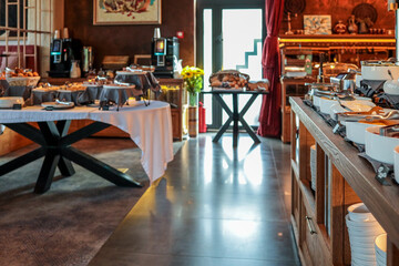 Elegant hotel breakfast buffet with a variety of dishes, cereals, bread, and fresh food. Modern self-service station in a cozy restaurant interior with stylish decor